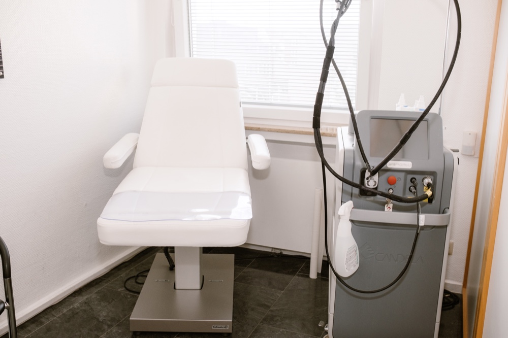 Behandlungsstuhl und medizinisches Lasergerät im Praxisraum